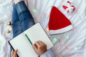 Writing in bed next to a Santa Hat