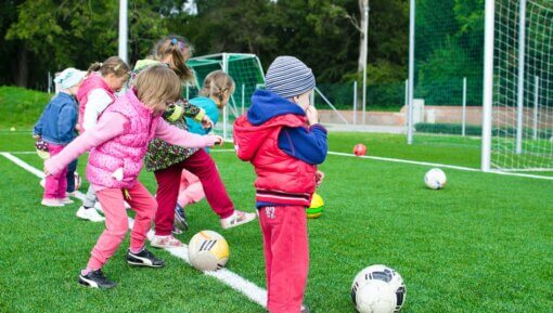 Toddlers shooting at a goal while playing soccer
