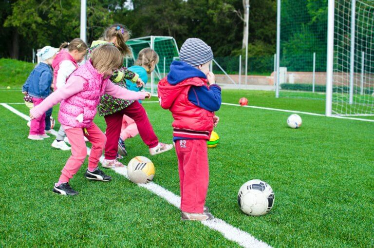 Toddlers shooting at a goal while playing soccer