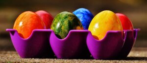 Colorful easter eggs in a purple carton