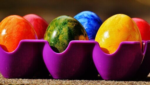 Colorful easter eggs in a purple carton