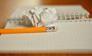 pencil, notebook, and balled up scrap of paper.